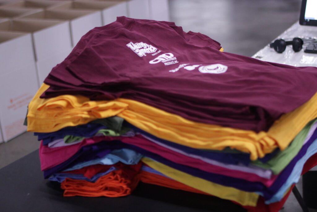 Stapel bedruckter T-Shirts in verschiedenen Farben